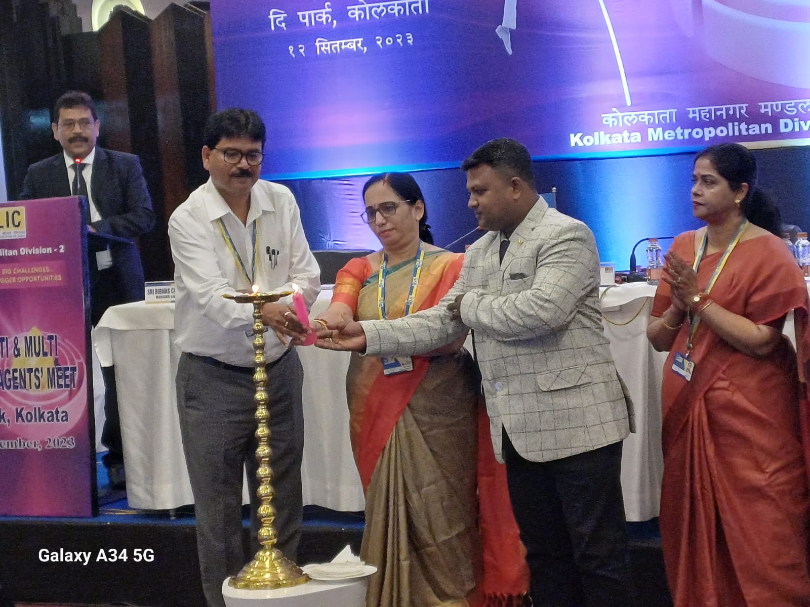 back view of woman wearing a backpack and beanie waiting to cross the road on a busy street at night in New York City, USA